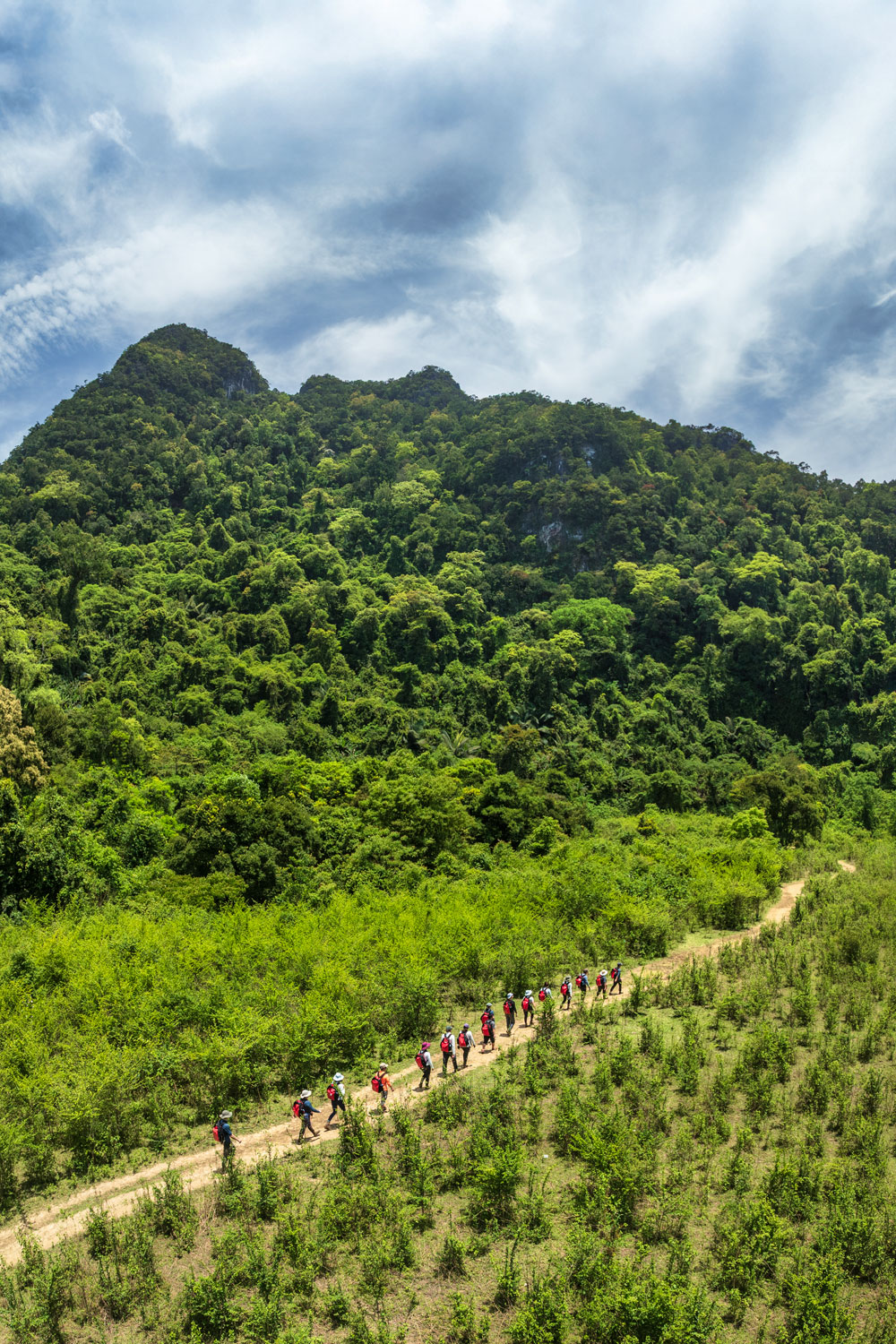 The trekking trail winds through a lush green valley.